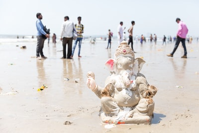 主Ganesh塑像附近的白色沙滩上人们白天
